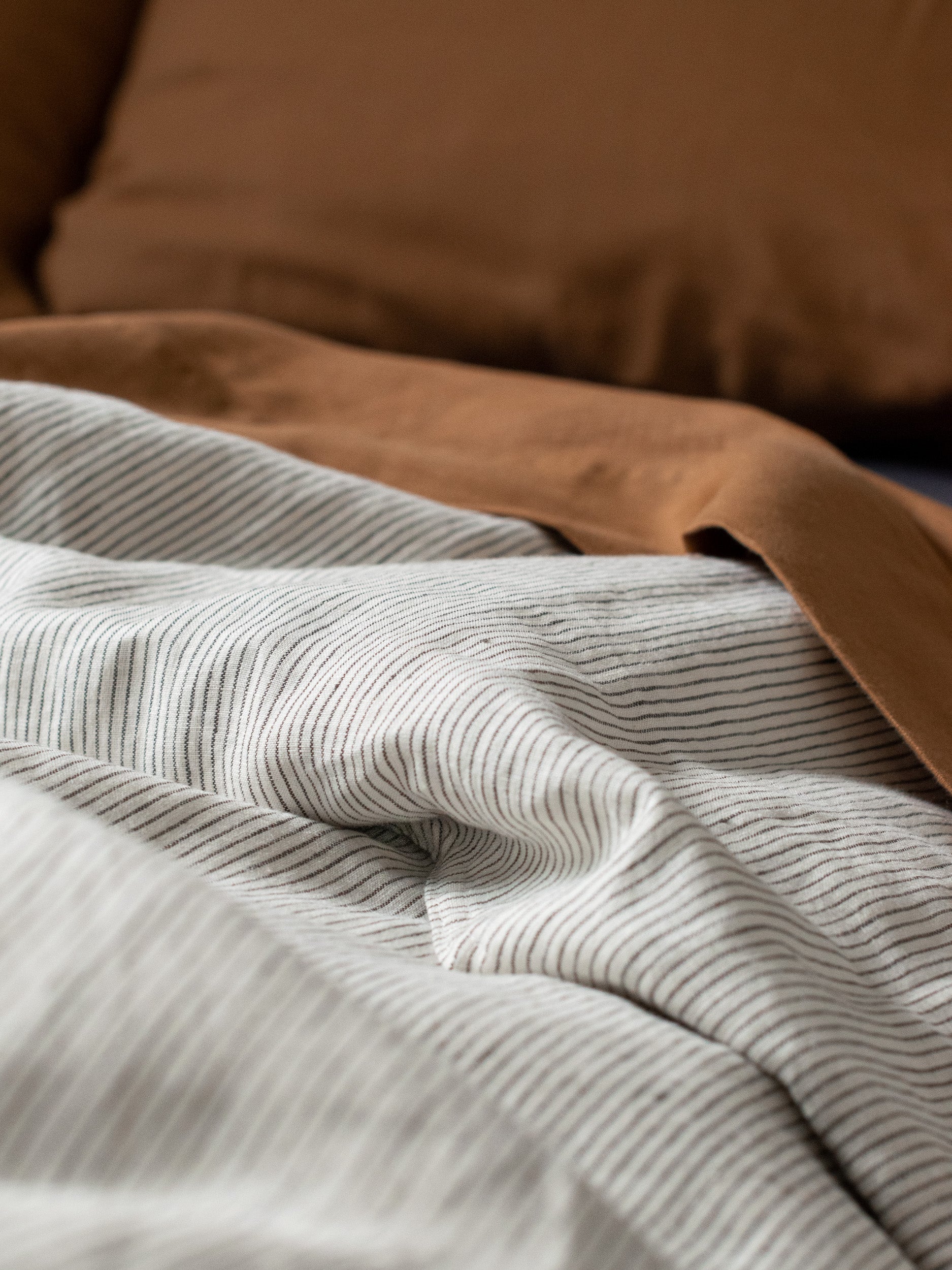 A bed with white linen sheets